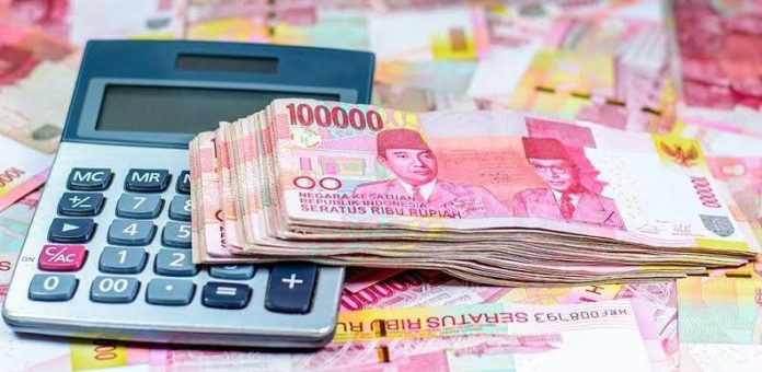 ilustrasi kalkulator dan beberapa lembar uang kertas rupiah